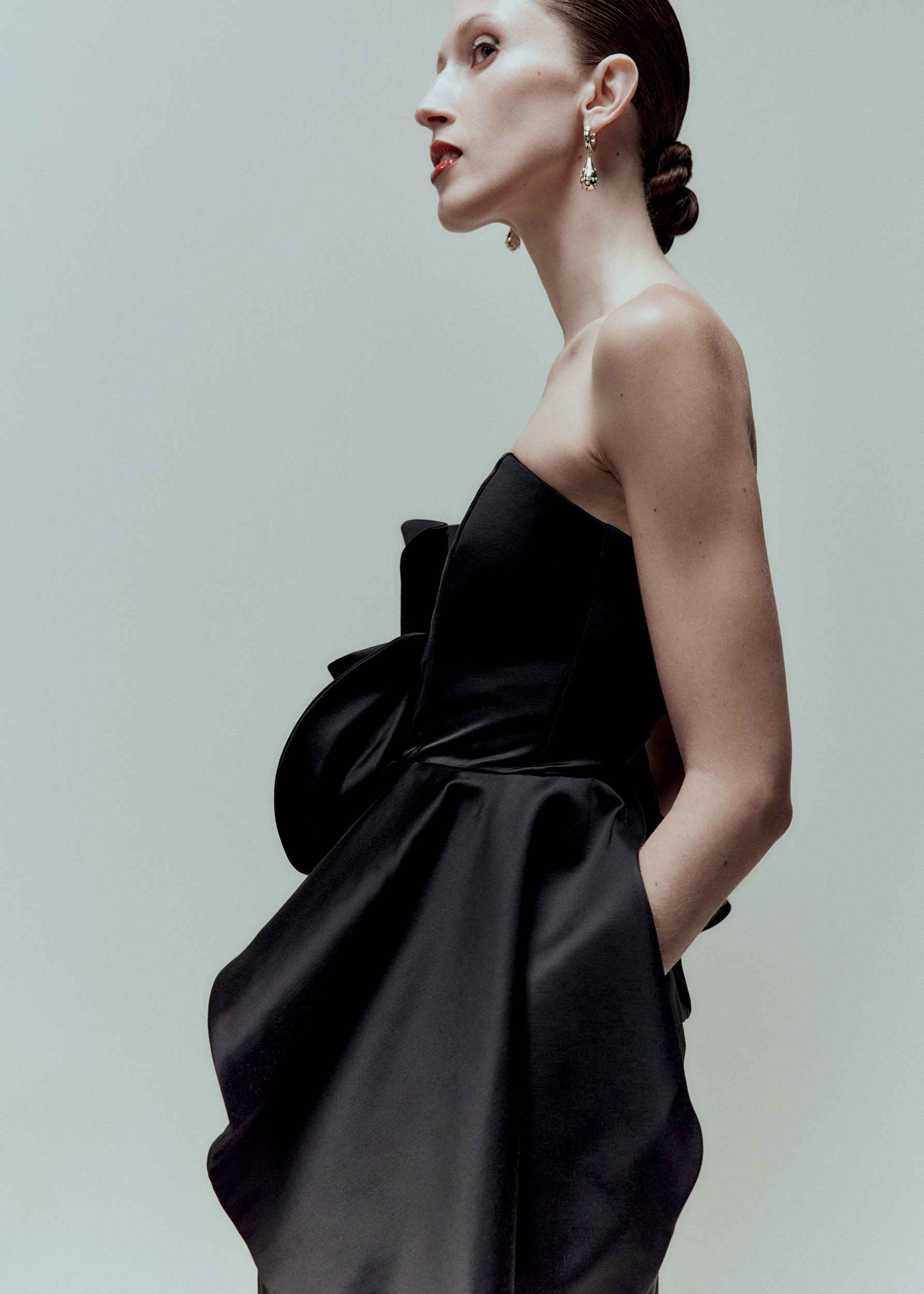 woman from the side wearing black strapless dress