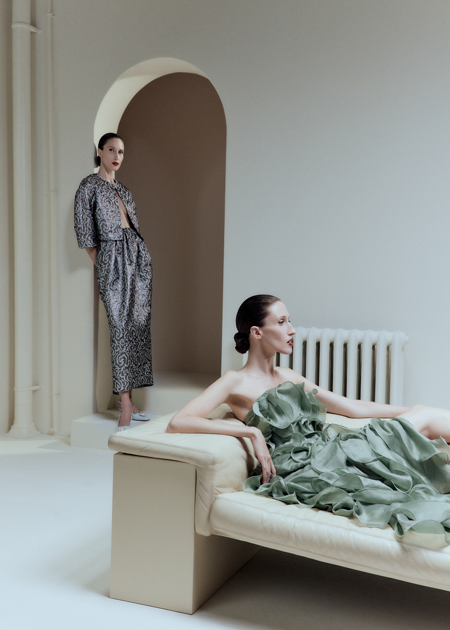 Two women, one in silver set, other one in green ruffled dress