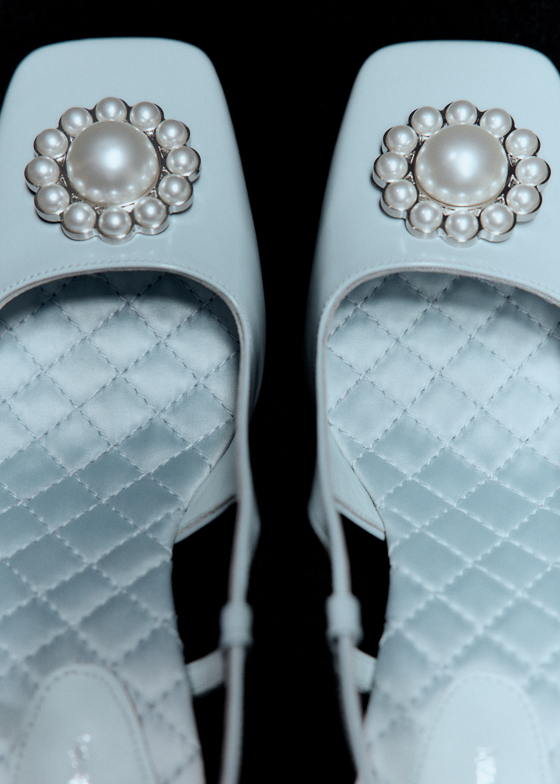 closeup of a pair of square toe heels with peal embellishments